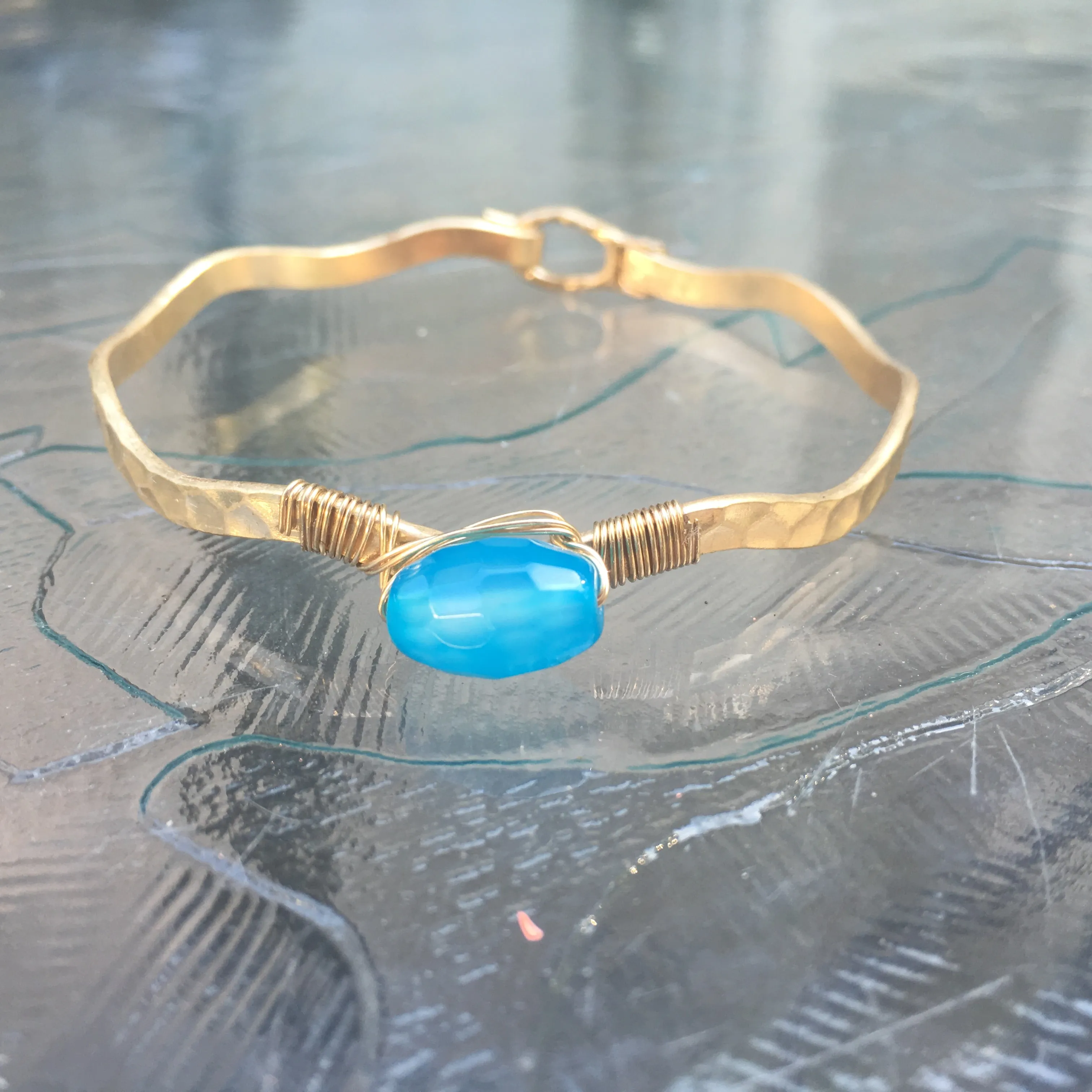 Worn Gold Tone Wavy Latch Bangle with Stone- Blue