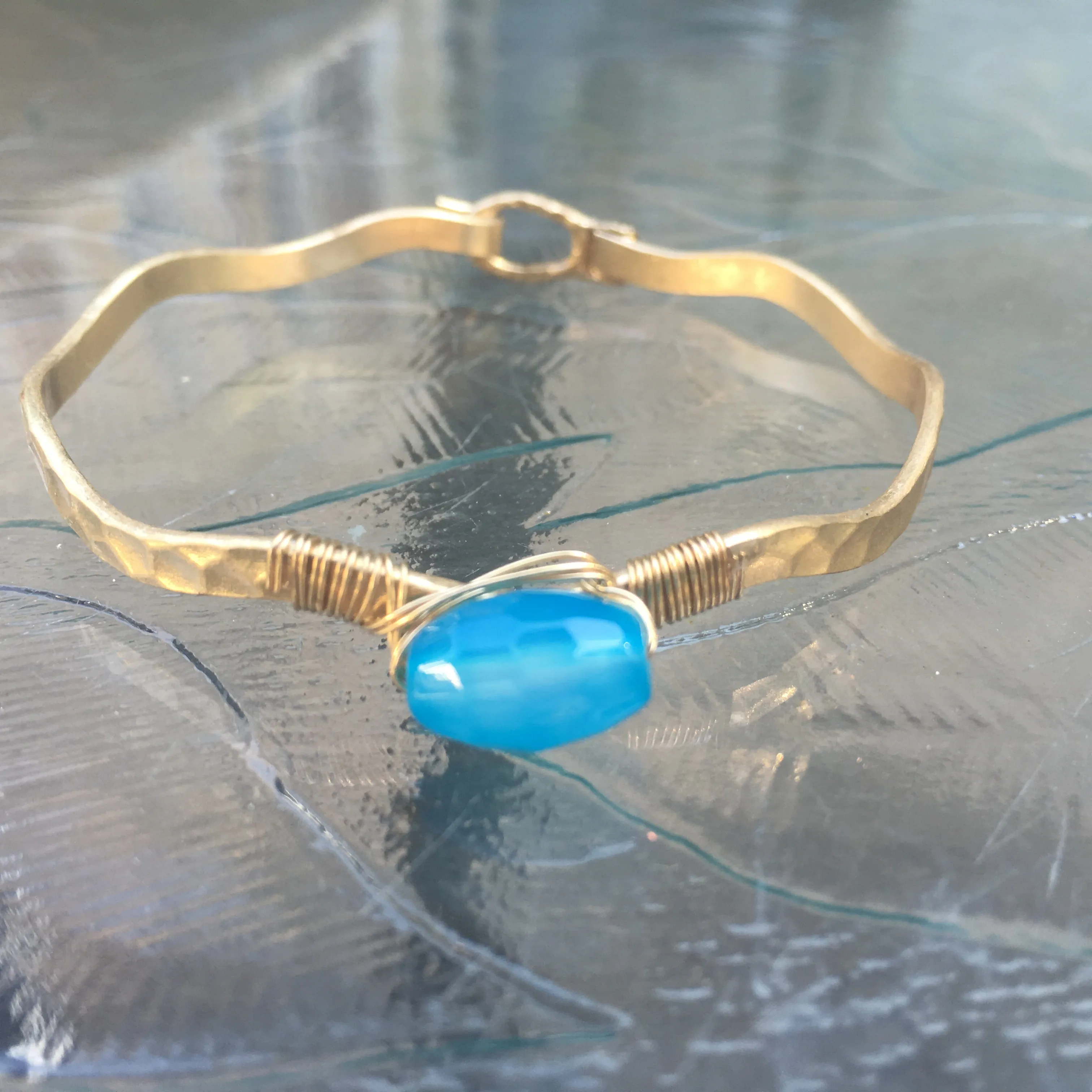 Worn Gold Tone Wavy Latch Bangle with Stone- Blue